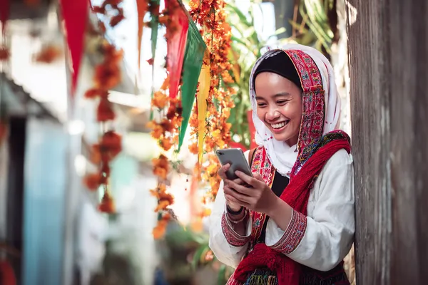 A player using their smartphone during a festive local event, representing F7 F7’s fully mobile-friendly casino.